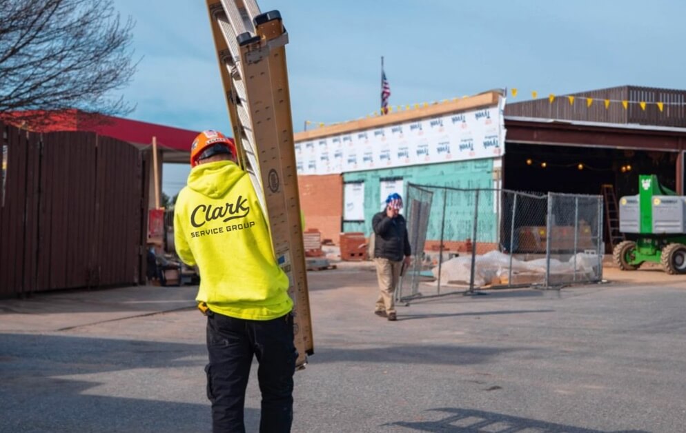 Installation technician bringing a ladder to a job site