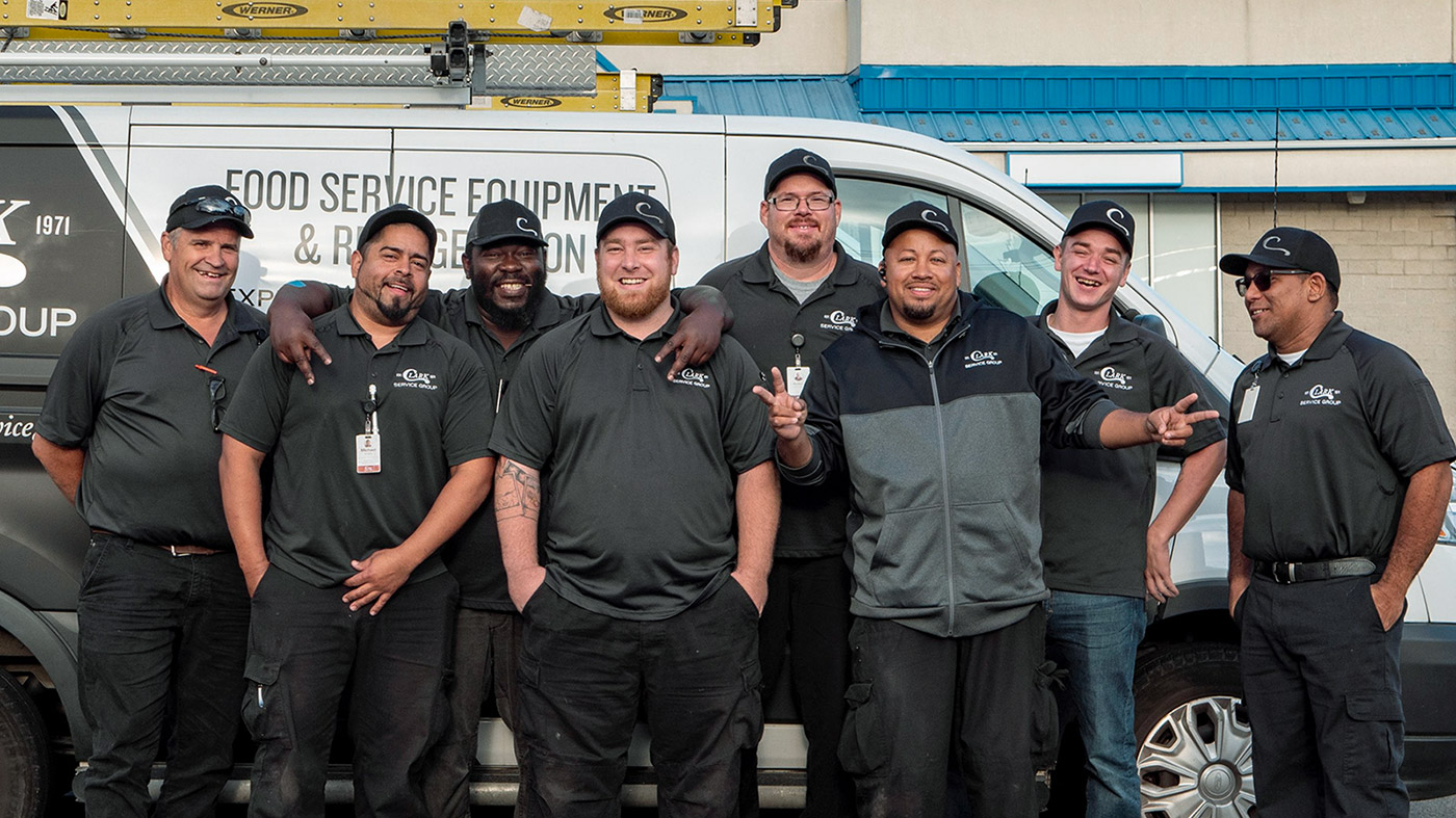 A group of field technicians smiling for a group photo